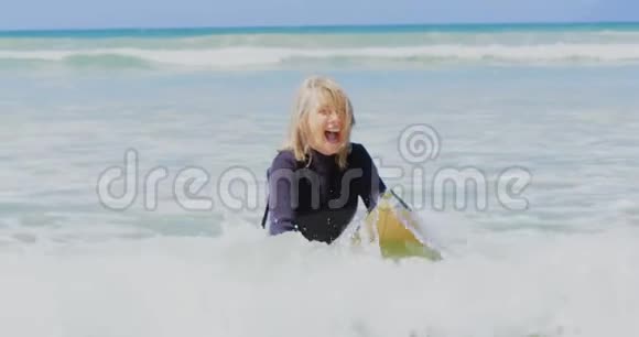 积极向上的高加索女性冲浪者在阳光下海上冲浪的正面景色视频的预览图