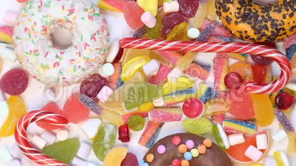 很多五颜六色的糖果美味的开胃派对配饰生日快乐甜食旋转糖果棒棒糖视频的预览图