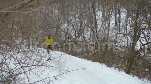 在冬季森林里一个长着胡须的雄性慢跑者跑上山视频的预览图