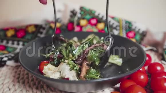 黑色盘子里有沙拉勺子混合沙拉慢动作视频的预览图