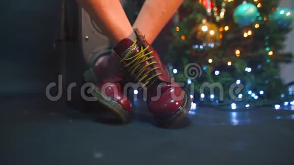 一个坐着的女孩的脚在聚会上穿过一棵新年树视频的预览图
