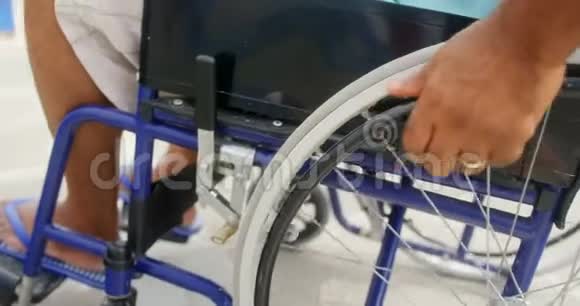 残疾积极行动的老年非裔美国人在长廊4k移动轮椅的特写镜头视频的预览图