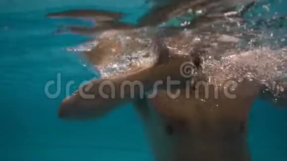 运动的男人在游泳池里的水下游泳竖起大拇指视频的预览图