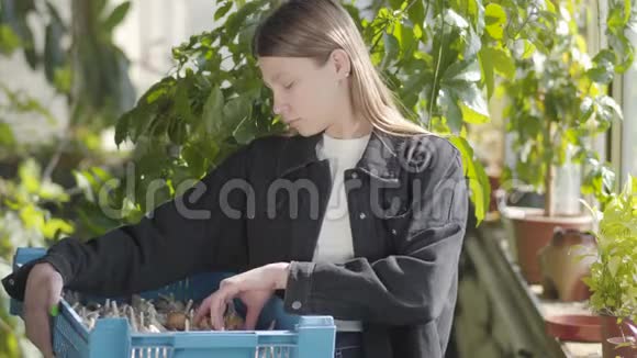 乡村女孩检查她的收获年轻女子手里拿着大蒜和洋葱的盒子女农民视频的预览图