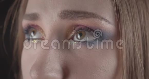 一张年轻滑稽的白种人短发女性脸的特写肖像她的眼睛在前面摆着闪闪发光的妆容视频的预览图