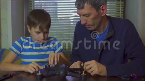 男孩和父亲组装无人机复印机4K视频的预览图