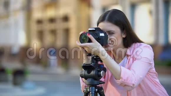 微笑的女摄影师聚焦镜头目标街道照片拍摄视频的预览图