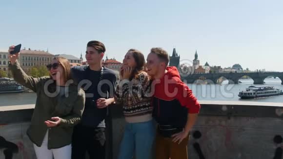 年轻的一群朋友站在桥上自拍看着它视频的预览图