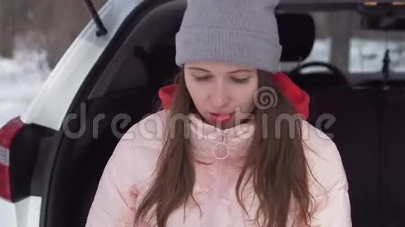 一个美丽的女孩坐在冬天的森林里微笑着翻阅着新闻视频的预览图