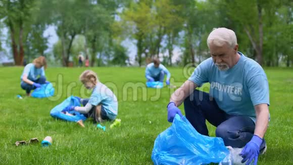 老人一起在公园里捡垃圾家庭微笑相机地球护理视频的预览图