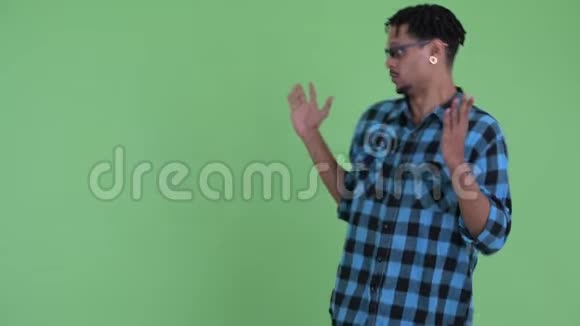 年轻快乐的非洲时髦男人摸着东西看上去很惊讶视频的预览图