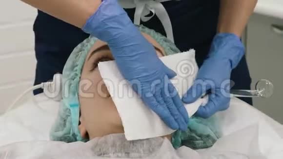 美容师的特写镜头用纸餐巾客户的脸视频的预览图