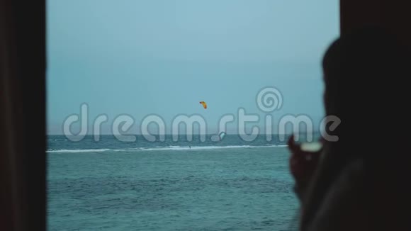 女人喝葡萄酒看看人们如何风筝冲浪在美丽的清澈的水在达哈布埃及探索蓝色的大海视频的预览图