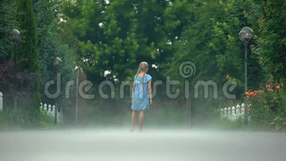 开朗的女孩挥舞着手光着脚站在阴霾中神秘的气氛视频的预览图