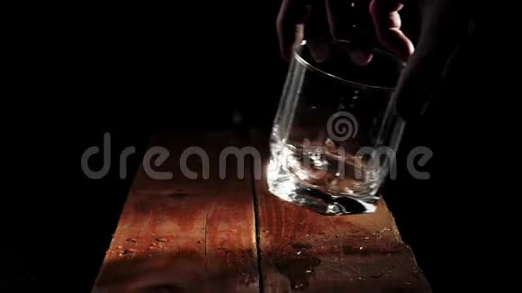 豪华威士忌手把一个空玻璃放在棕色的木桌上背景是黑色的准备饮酒视频的预览图