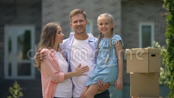 妻子和女儿亲吻幸福的男人搬进新公寓梦想成真视频的预览图