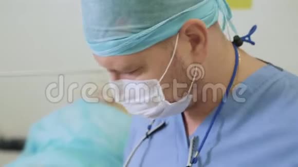 手术期间手术室无菌口罩及帽子医生的特写照片视频的预览图