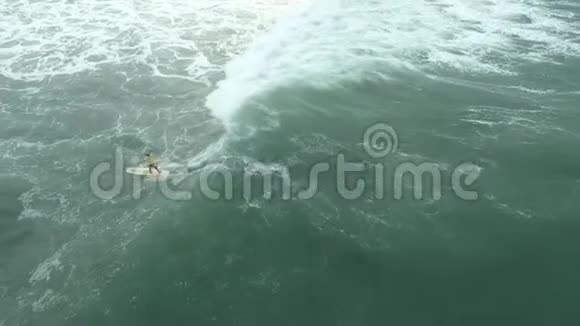 一个女人冲浪大海浪高角度镜头巴厘岛的俯视图视频的预览图