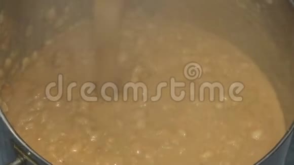 热的煮豆子从水龙头漏入锅中视频的预览图