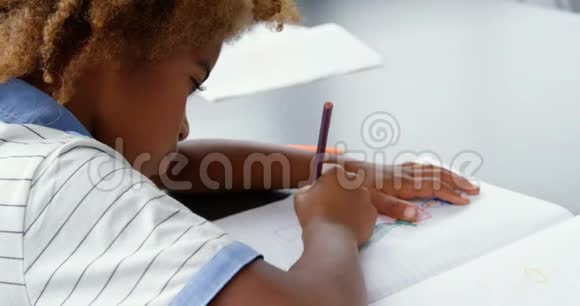 美国非洲人的侧视图在教室4k的笔记本上绘制草图视频的预览图