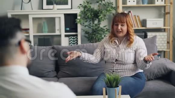 情绪化的年轻女性肥胖患者在心理医生的微笑下讨论问题视频的预览图