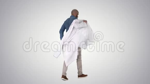 步行医生把白色长袍放在渐变背景上视频的预览图