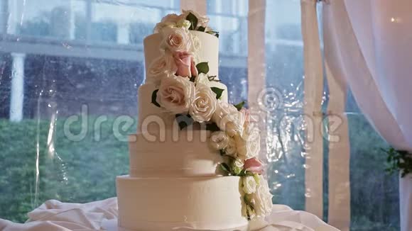 用大玫瑰装饰漂亮的四层婚礼蛋糕视频的预览图