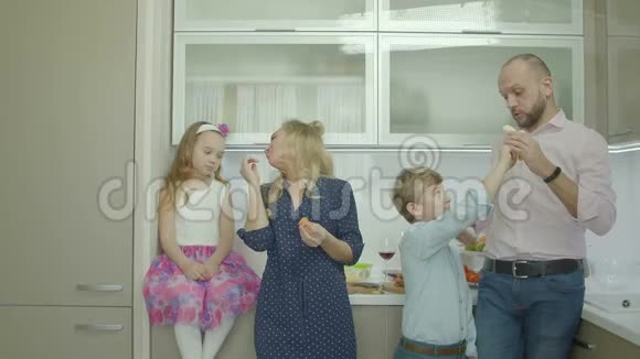 快乐的父母和兄弟姐妹在厨房分享水果视频的预览图