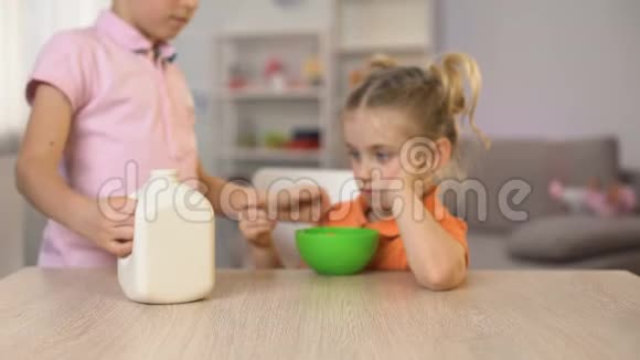 哥哥把牛奶倒在玉米片碗里照顾妹妹家人的爱视频的预览图