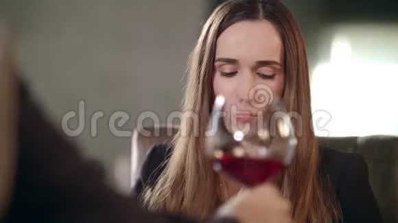 女人和餐馆里的男人碰着红酒杯喝红酒的女人视频的预览图