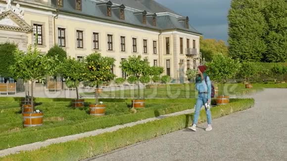 德国汉诺威在一座美丽的中世纪宫殿附近种植的柑橘山梨树和橘子年轻女性视频的预览图