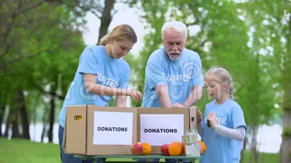 志愿者放置罐头食品和水果捐赠箱帮助穷人视频的预览图