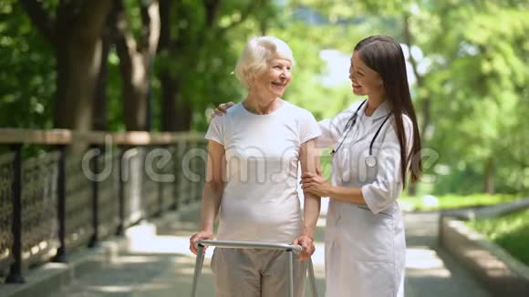 女医生抱着老太太走着走着在室外对着镜头微笑视频的预览图