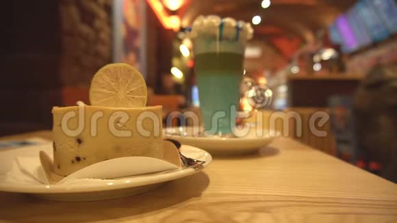 美味的芝士蛋糕放在桌子上杯子里放一杯鸡尾酒咖啡馆和游客舒适的氛围复制空间视频的预览图