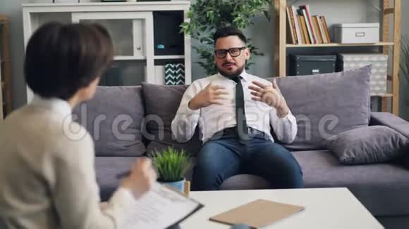穿着正式服装的家伙商人在办公室里和心理医生交流问题视频的预览图