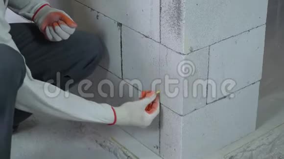 工人在砌块墙上钻孔时插入销钉的倾斜向上弹丸视频的预览图