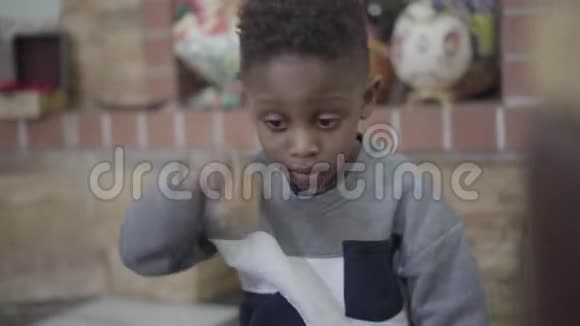 美国非裔小男孩的肖像专注于在客厅玩和玩玩具视频的预览图