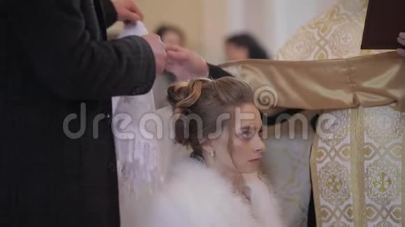 优雅的新娘在一座古老的教堂里一个男人头上戴着围巾对妻子说视频的预览图
