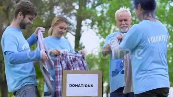 快乐的积极分子把捐赠的衣物放在盒子里给高五做志愿者视频的预览图