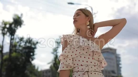 美丽优雅的女人穿着裙子在夏季城市摆姿势慢动作视频的预览图