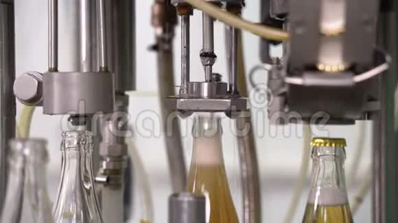 在工厂用玻璃瓶装柠檬水带玻璃瓶的传送带输送机特写的进程视频的预览图