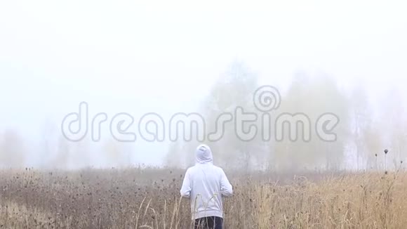 一个孤独的人在田里围着肚子从后面看视频的预览图