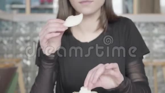 美丽的黑发女孩吃美味的薄面包或脆面包视频的预览图