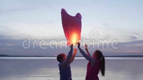 日落时分孩子们在海上放飞天灯视频的预览图