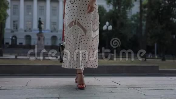 美丽优雅的女人穿着裙子在夏季城市摆姿势慢动作视频的预览图