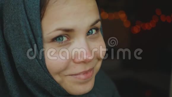 蓝眼睛对着镜头微笑的漂亮女人的肖像戴头巾的女人慢动作4k视频的预览图
