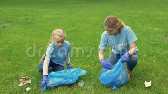 女青年和女学生在公园里高五收集垃圾视频的预览图