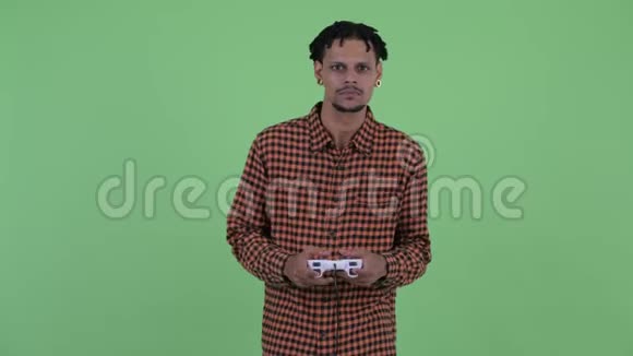 快乐年轻英俊的非洲男人玩游戏赢了视频的预览图