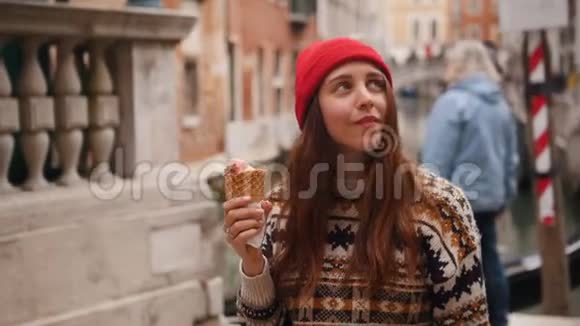 年轻的女人站在会说话的人的背景上吃冰淇淋视频的预览图