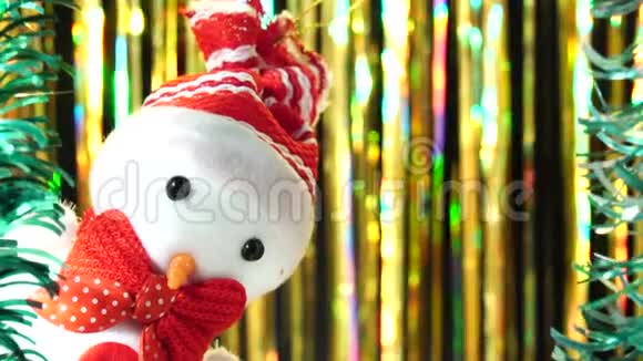 可爱的雪人戴着红帽子鞠躬从现场看着你金色背景的圣诞问候新年节日主题视频的预览图